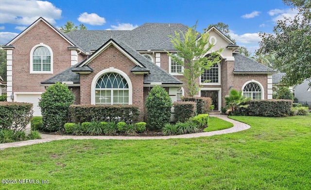 3355 Bishop Estates Rd, Saint Johns, FL 32259 - traditional-style home with brick siding, a front lawn, roof with shingles, and a garage