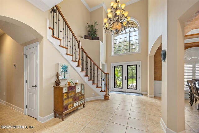 3355 Bishop Estates Rd, Saint Johns, FL 32259 - entryway with arched walkways, a chandelier, light tile patterned flooring, stairway, and a high ceiling
