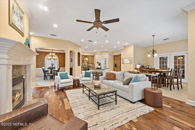 3355 Bishop Estates Rd, Saint Johns, FL 32259 - living area with a chandelier, arched walkways, a premium fireplace, a ceiling fan, and wood finished floors