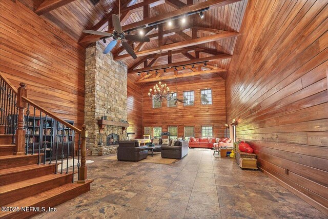 3355 Bishop Estates Rd, Saint Johns, FL 32259 - living room featuring high vaulted ceiling, wood walls, stairs, wooden ceiling with exposed beams, and an outdoor stone fireplace