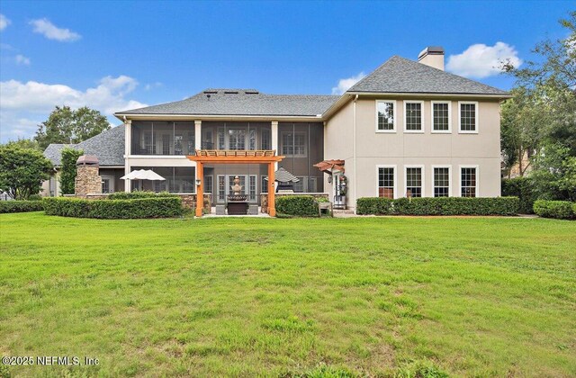 3355 Bishop Estates Rd, Saint Johns, FL 32259 - rear view of property featuring a sunroom, a chimney, a lawn, and stucco siding