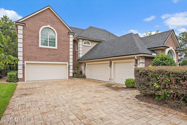 3355 Bishop Estates Rd, Saint Johns, FL 32259 - view of front facade with brick siding, decorative driveway, roof with shingles, and an attached garage