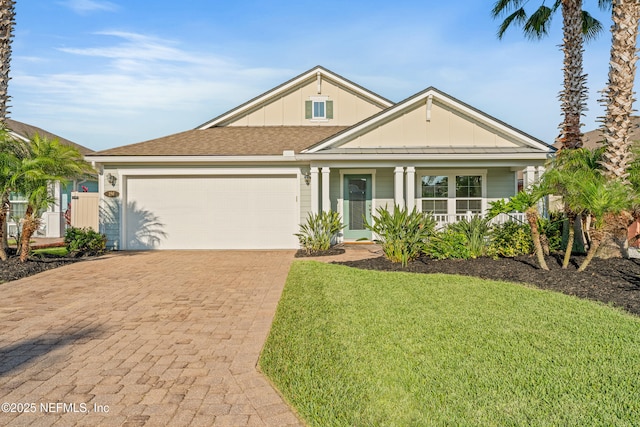 186 Ocean Cay Blvd, Saint Augustine, FL 32080 - view of front of property featuring board and batten siding, decorative driveway, an attached garage, a front lawn, and a shingled roof