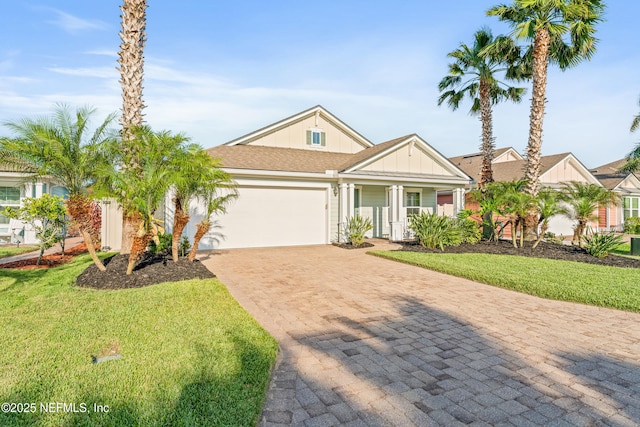 186 Ocean Cay Blvd, Saint Augustine, FL 32080 - view of front of property with board and batten siding, decorative driveway, a garage, a front yard, and covered porch
