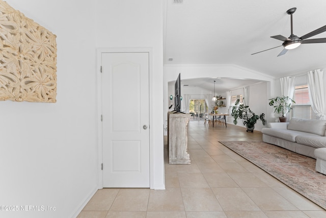 186 Ocean Cay Blvd, Saint Augustine, FL 32080 - living room with vaulted ceiling, arched walkways, light tile patterned flooring, ceiling fan, and baseboards