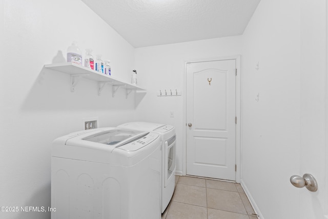 186 Ocean Cay Blvd, Saint Augustine, FL 32080 - laundry room with washer and clothes dryer, light tile patterned flooring, a textured ceiling, and baseboards