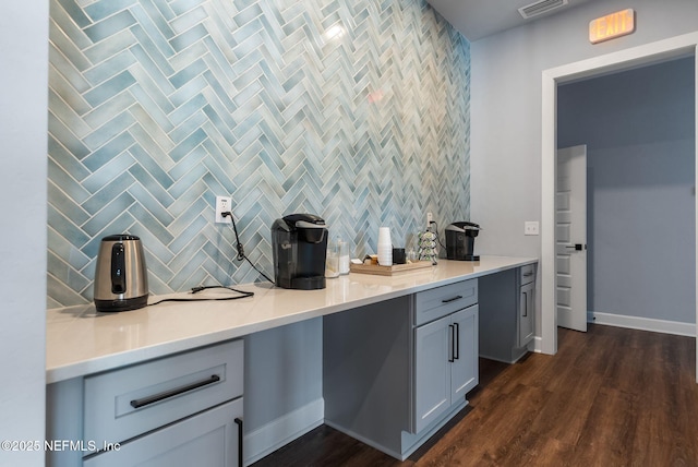 kitchen featuring tasteful backsplash, dark wood-style flooring, baseboards, and light countertops