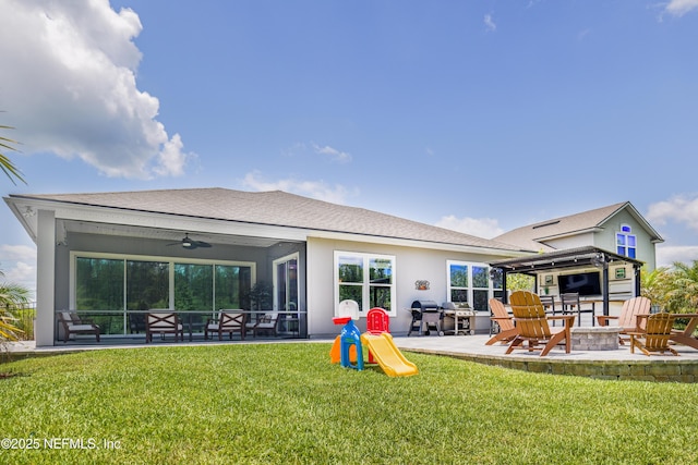 310 Cedarstone Way, Saint Augustine, FL 32092 - back of house featuring a fire pit, a patio area, a lawn, stucco siding, and ceiling fan