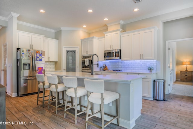 310 Cedarstone Way, Saint Augustine, FL 32092 - kitchen featuring stainless steel appliances, a kitchen island with sink, light countertops, white cabinets, and backsplash