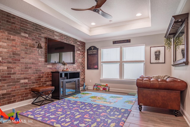 310 Cedarstone Way, Saint Augustine, FL 32092 - living room featuring wood finished floors, ceiling fan, baseboards, a raised ceiling, and a glass covered fireplace