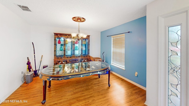 124 Lindsay Dr, Palm Coast, FL 32137 - dining area featuring a chandelier, light wood-type flooring, baseboards, and a textured ceiling