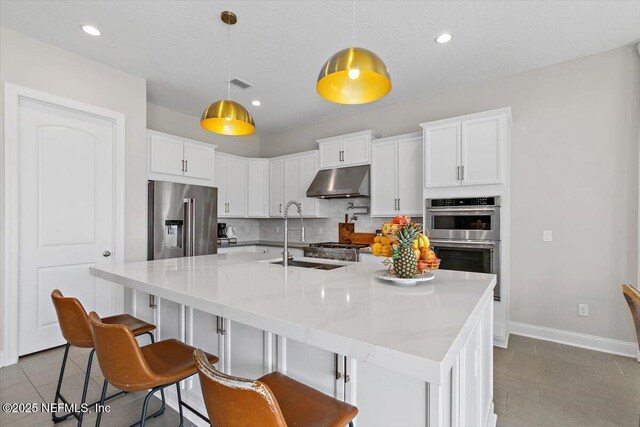 45 Waterwheel Ct, Saint Johns, FL 32259 - kitchen featuring appliances with stainless steel finishes, tile patterned floors, under cabinet range hood, decorative backsplash, and baseboards