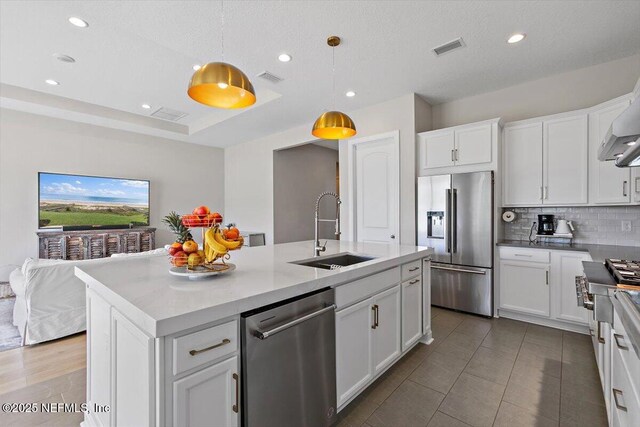 45 Waterwheel Ct, Saint Johns, FL 32259 - kitchen with appliances with stainless steel finishes, a sink, tasteful backsplash, a kitchen island with sink, and white cabinets
