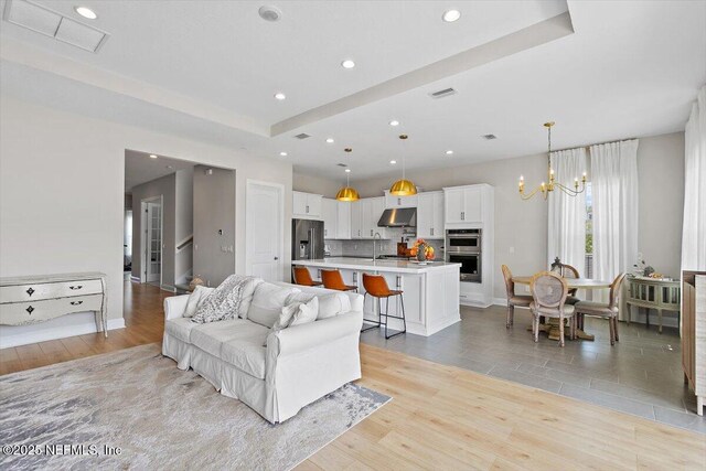 45 Waterwheel Ct, Saint Johns, FL 32259 - living area with recessed lighting, light wood-style floors, a tray ceiling, a chandelier, and baseboards