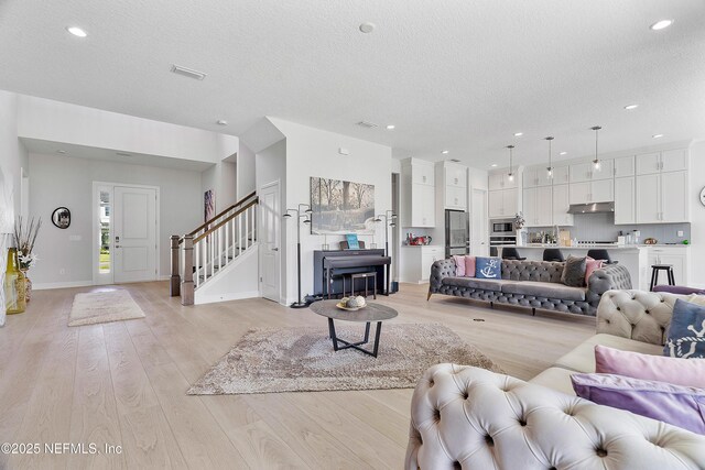 144 Waverly Way, Saint Johns, FL 32259 - living area with a textured ceiling, stairway, light wood-type flooring, recessed lighting, and baseboards