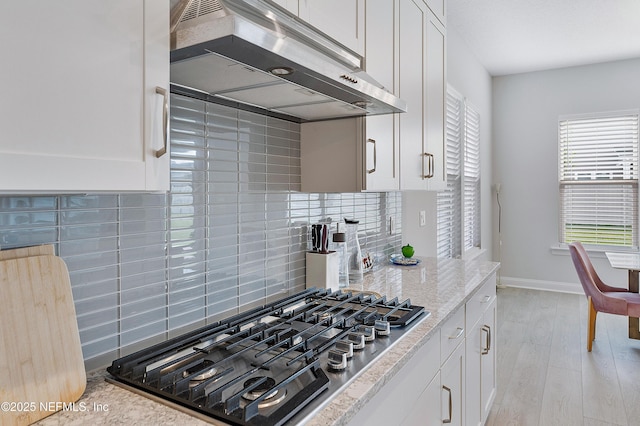 144 Waverly Way, Saint Johns, FL 32259 - kitchen with stainless steel gas cooktop, under cabinet range hood, white cabinetry, backsplash, and light wood-type flooring