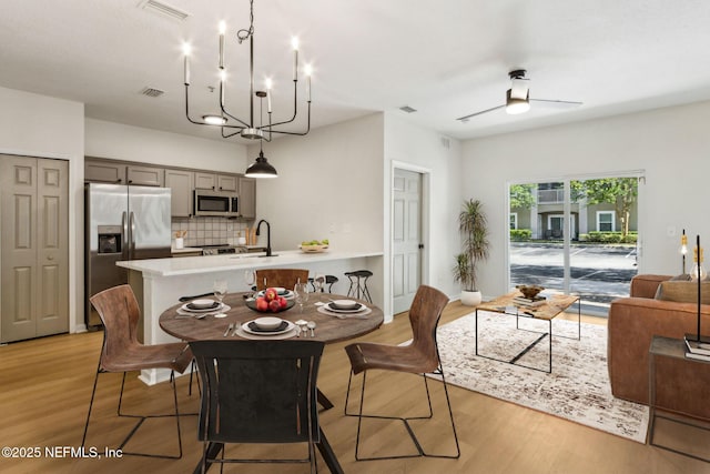 2330 Golden Lake Loop, Saint Augustine, FL 32084 - dining space with light wood-style flooring, ceiling fan, and a chandelier