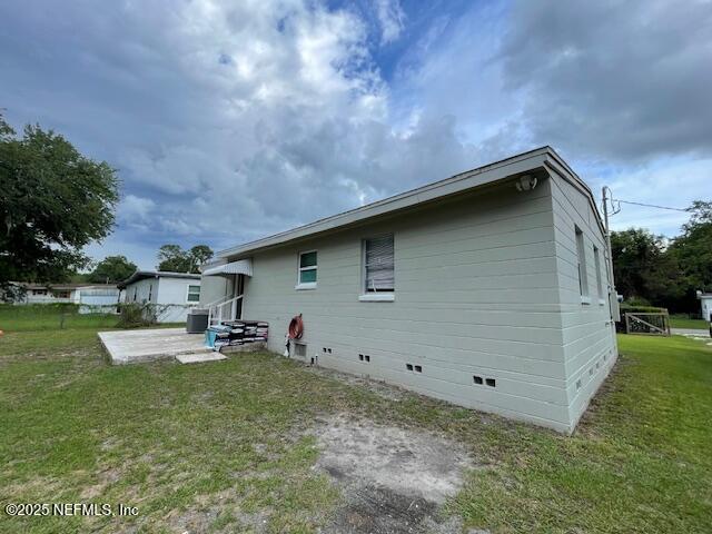 10566 Arendal Rd, Jacksonville, FL 32218 - back of house featuring crawl space, a patio area, a lawn, and cooling unit
