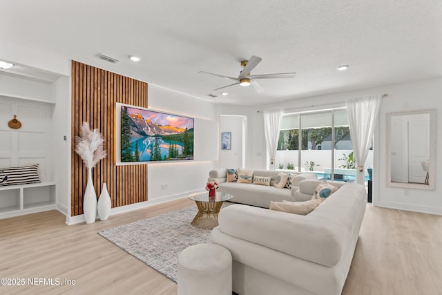 living room with wood finished floors, a ceiling fan, recessed lighting, and baseboards