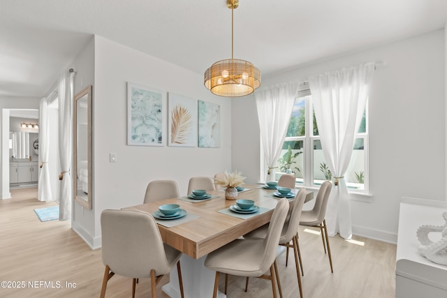 dining area featuring light wood-style flooring and baseboards