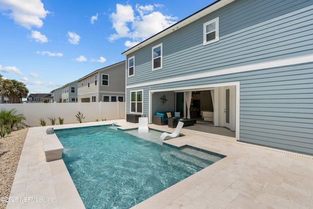 view of swimming pool with an outdoor living space, a patio, and a fenced backyard