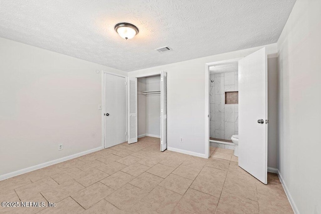 4504 Lincrest Dr S, Jacksonville, FL 32208 - unfurnished bedroom featuring a textured ceiling, light tile patterned floors, baseboards, a closet, and ensuite bath