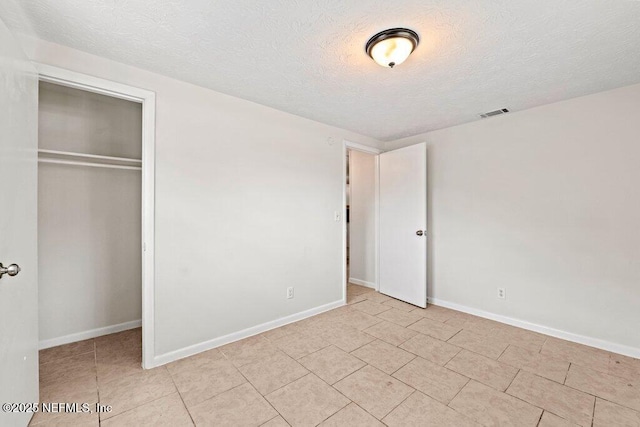 4504 Lincrest Dr S, Jacksonville, FL 32208 - unfurnished bedroom with a textured ceiling, a closet, baseboards, and light tile patterned floors