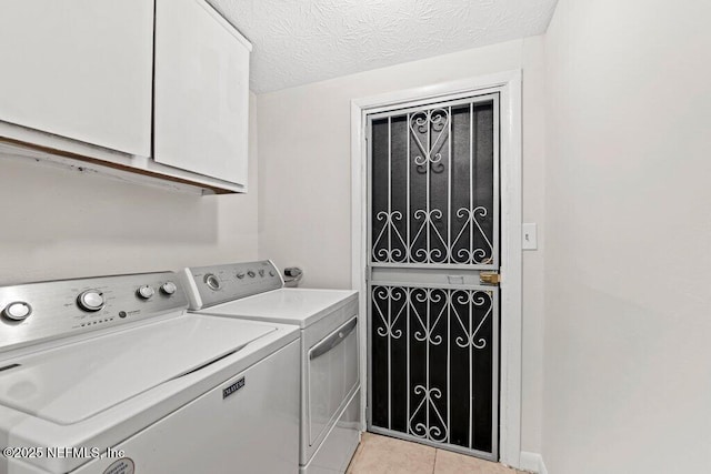 4504 Lincrest Dr S, Jacksonville, FL 32208 - laundry area featuring independent washer and dryer, cabinet space, light tile patterned flooring, and a textured ceiling