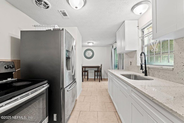 4504 Lincrest Dr S, Jacksonville, FL 32208 - kitchen featuring stainless steel electric range, a sink, light tile patterned floors, white cabinetry, and light stone countertops