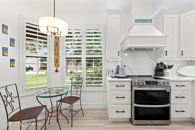 33 Loggerhead Ln, Ponte Vedra Beach, FL 32082 - kitchen featuring range with two ovens, custom exhaust hood, light countertops, white cabinetry, and light wood-style flooring