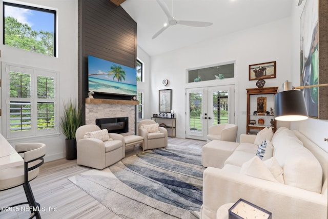 33 Loggerhead Ln, Ponte Vedra Beach, FL 32082 - living area with high vaulted ceiling, a stone fireplace, french doors, a ceiling fan, and light wood-style flooring