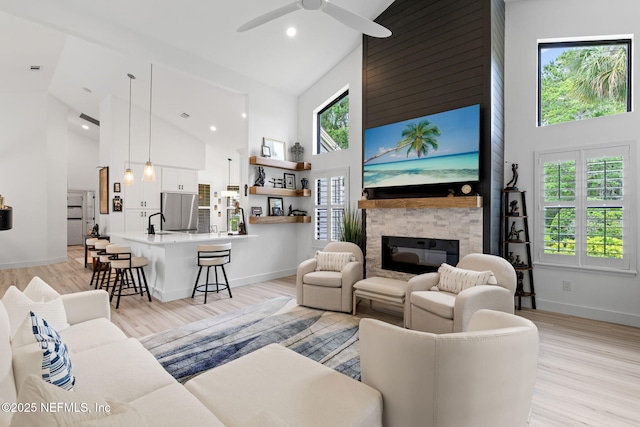 33 Loggerhead Ln, Ponte Vedra Beach, FL 32082 - living area with high vaulted ceiling, a stone fireplace, ceiling fan, baseboards, and light wood finished floors