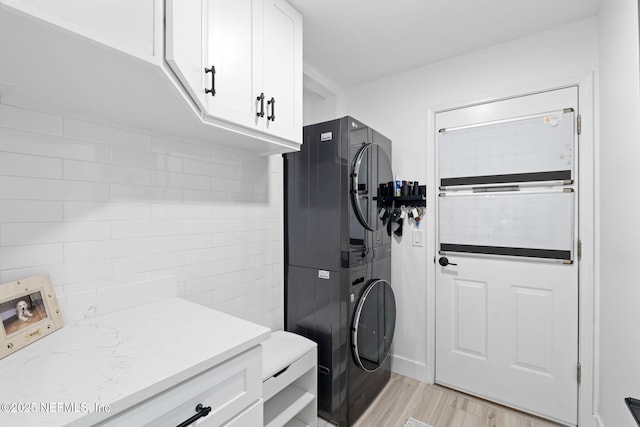 33 Loggerhead Ln, Ponte Vedra Beach, FL 32082 - laundry area featuring estacked washer and dryer, cabinet space, and light wood-style flooring