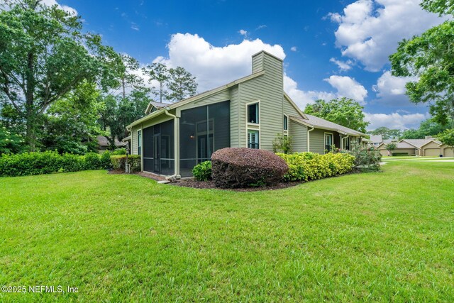 33 Loggerhead Ln, Ponte Vedra Beach, FL 32082 - rear view of house with a sunroom, a lawn, and a chimney