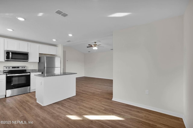 37135 Whippoorwill Ct, Hilliard, FL 32046 - kitchen with appliances with stainless steel finishes, baseboards, dark stone counters, ceiling fan, and white cabinetry