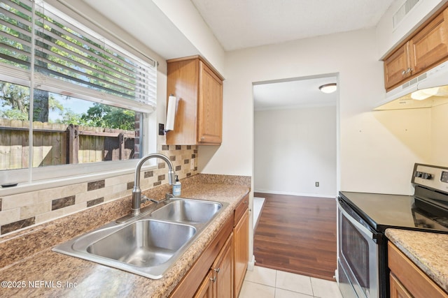 4813 Cherwell Ln Unit B-4-C, Jacksonville, FL 32217 - kitchen with stainless steel range with electric cooktop, a sink, under cabinet range hood, backsplash, and light tile patterned flooring