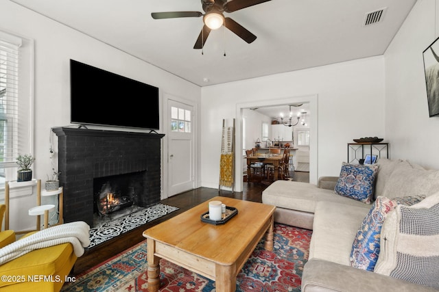1267 Murray Dr, Jacksonville, FL 32205 - living room with wood finished floors, ceiling fan, a brick fireplace, and a chandelier