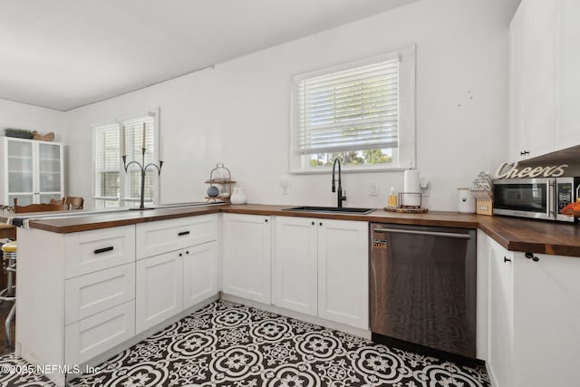 1267 Murray Dr, Jacksonville, FL 32205 - kitchen featuring butcher block countertops, stainless steel appliances, a sink, a peninsula, and white cabinets