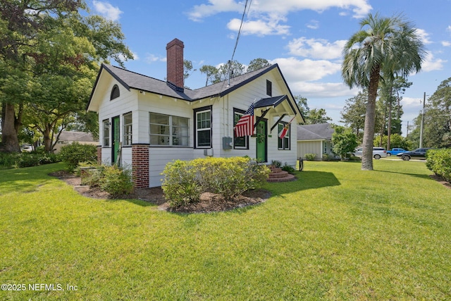 1267 Murray Dr, Jacksonville, FL 32205 - view of side of home with a chimney, a lawn, and a shingled roof