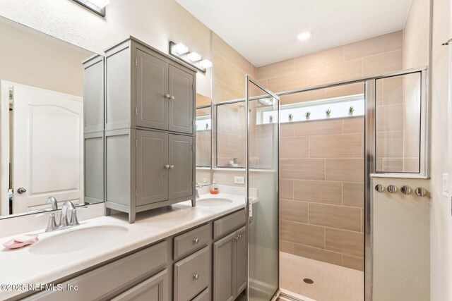 bathroom featuring a stall shower and double vanity