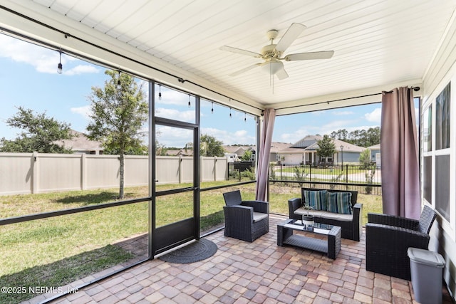 sunroom with an outdoor living space, a ceiling fan, and a residential view