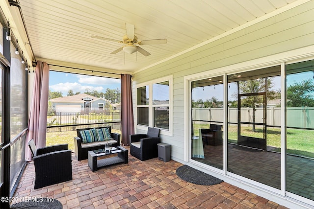 sunroom / solarium with a ceiling fan and an outdoor living space