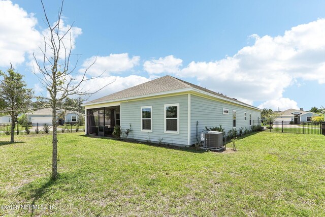 rear view of property featuring central AC unit, a sunroom, and roof with shingles