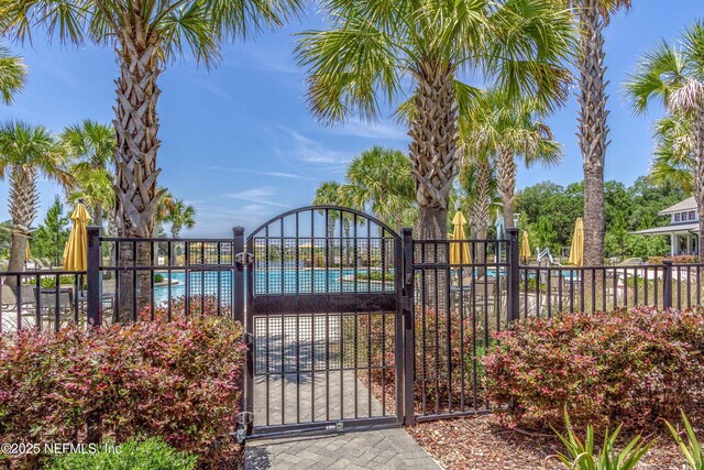 gate featuring fence and a community pool