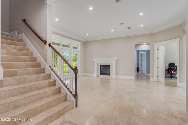 2624 Oakgrove Ave, Saint Augustine, FL 32092 - unfurnished living room with crown molding, arched walkways, recessed lighting, stairway, and baseboards