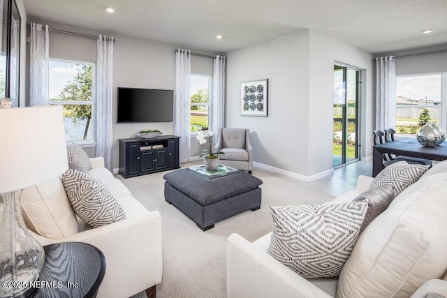 living room featuring plenty of natural light, baseboards, recessed lighting, and carpet floors