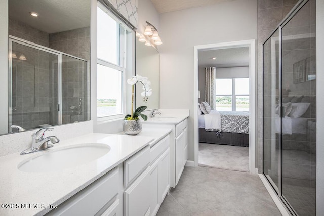 ensuite bathroom featuring a stall shower, double vanity, and tile patterned flooring