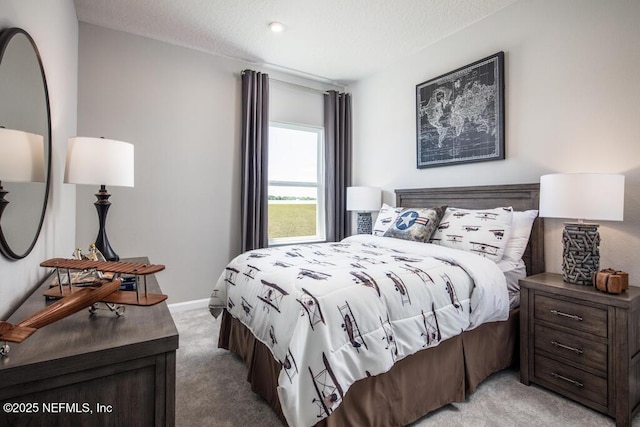 bedroom with light carpet, baseboards, and a textured ceiling