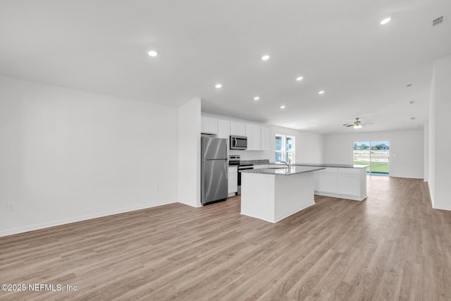 37143 Whippoorwill Ct, Hilliard, FL 32046 - kitchen featuring appliances with stainless steel finishes, open floor plan, an island with sink, a sink, and light wood finished floors