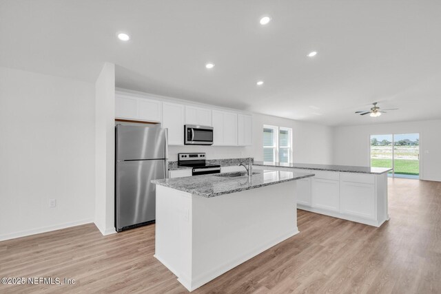 37143 Whippoorwill Ct, Hilliard, FL 32046 - kitchen featuring stainless steel appliances, a sink, healthy amount of natural light, white cabinets, and recessed lighting